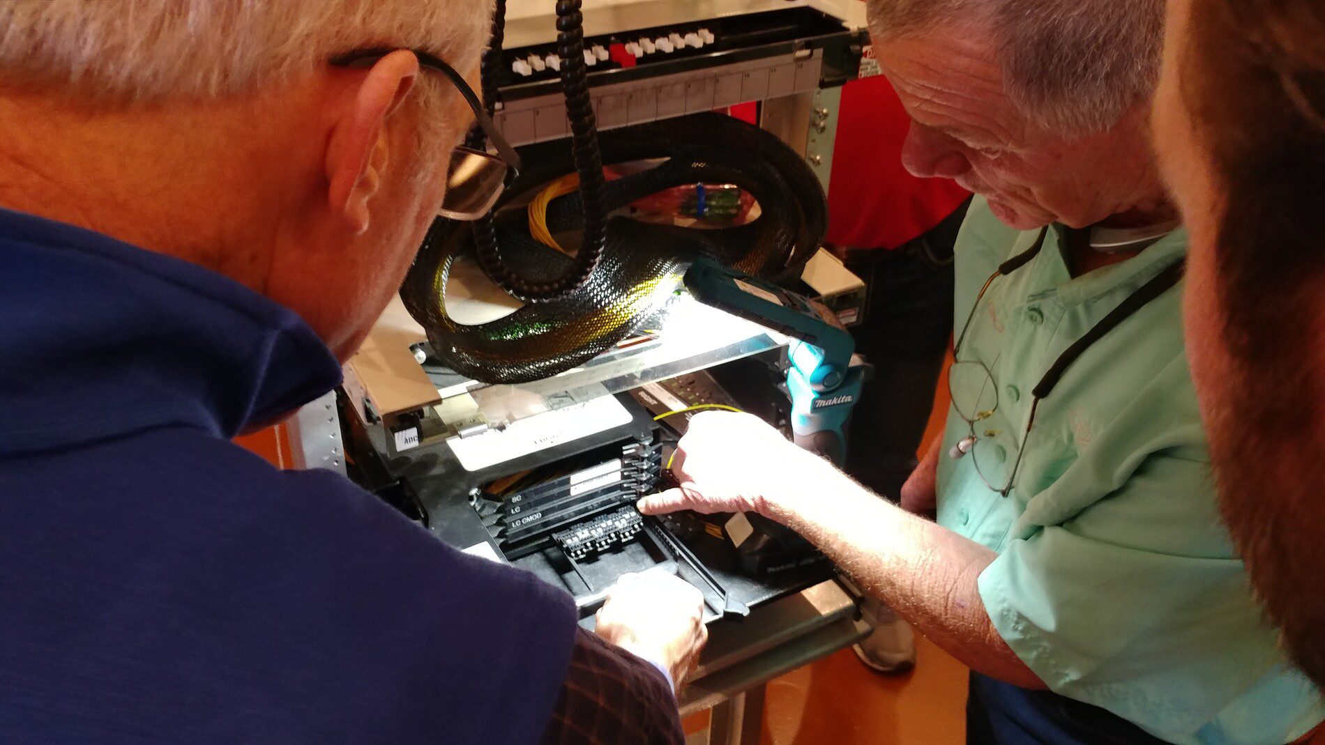Team Collaboration Hardware Repair Technicians examine fiber network equipment at Rep Com International, a broadband manufacturer focused on customer satisfaction.